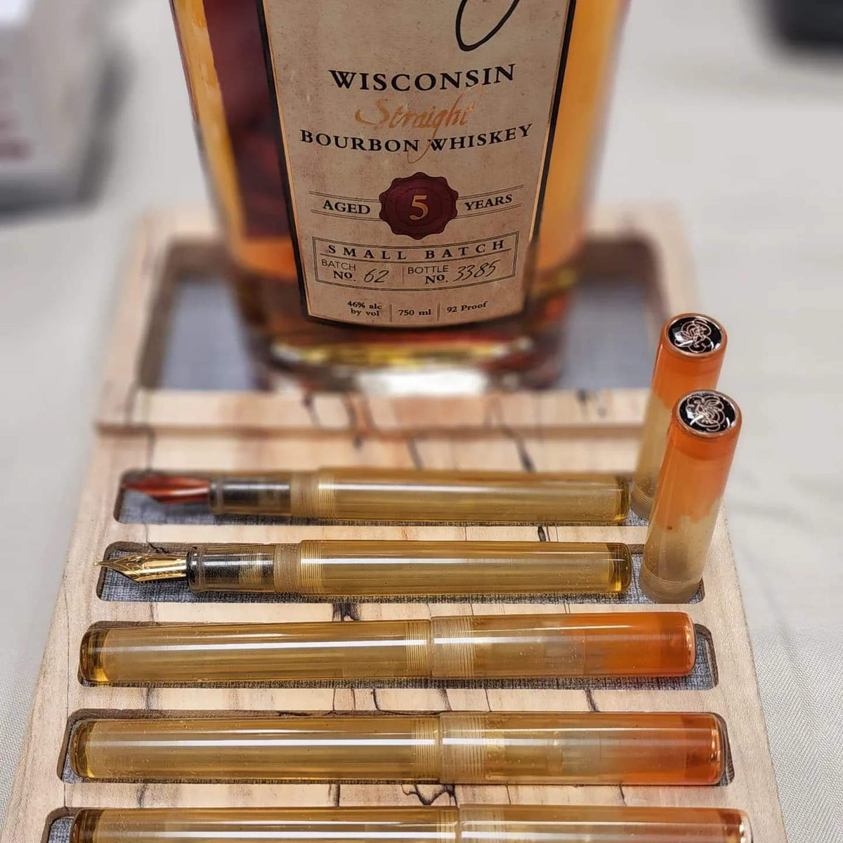 5 Gentlemen pens displayed with a bottle of burbon